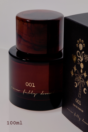 NFD Eau De Parfum 001 in boccetta di vetro ambrato con tappo tartarugato e scatola nera decorata in oro.