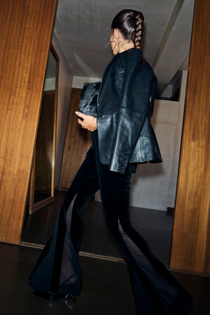 Black Leather Blazer in a relaxed fit, styled with sheer panel velvet flares and a faux fur clutch bag.
