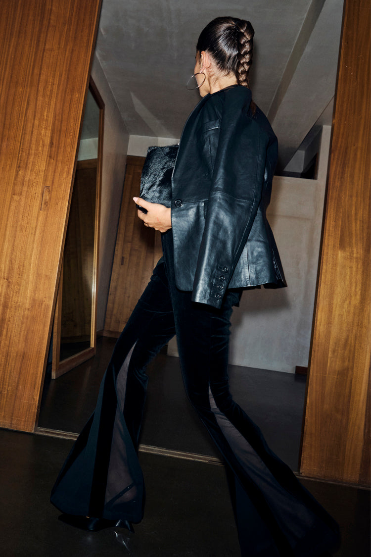 Black Leather Blazer in a relaxed fit, styled with sheer panel velvet flares and a faux fur clutch bag.