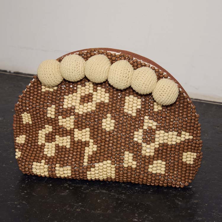 Jaden Beaded Clutch Bag featuring brown and cream patterned beads and statement cream crochet pom-poms.