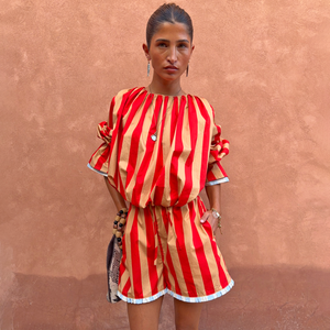 Model wearing Tomato Stripe Ellie Shorts and matching blouse in red and camel stripes with contrast hems.