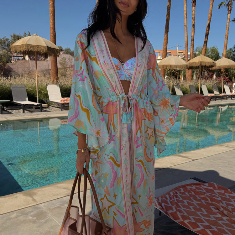 Blue Dreamer Maxi Kimono with palm and sun motifs, featuring a flowy silhouette and tie waist for a poolside look.