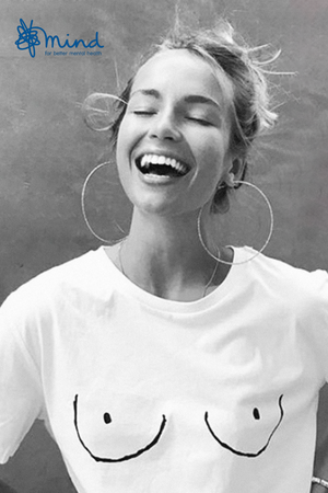 Iconic white Boob T-shirt with line drawing, worn by a laughing woman in support of Mind charity.