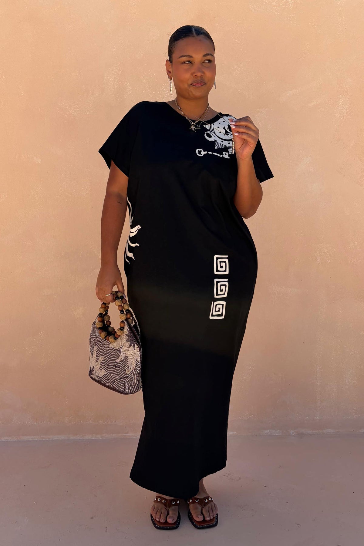 Black Dolce Vita T-Shirt Dress with hand-painted sun motifs and Greek graphics, styled as a multi-wear cotton maxi.