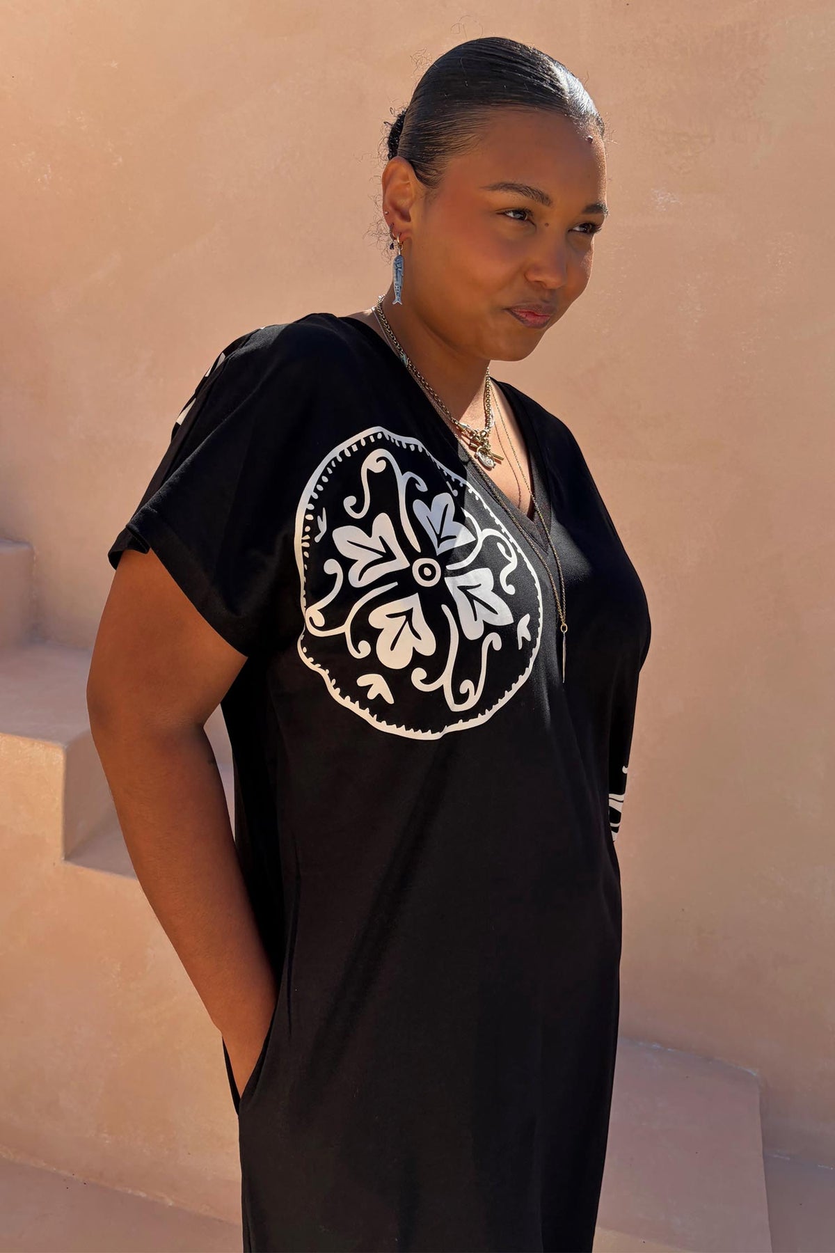 Multi-wear Black Dolce Vita T-Shirt Dress with a white sun motif and tee neckline, shown on a size XL model.