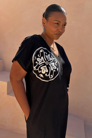 Multi-wear Black Dolce Vita T-Shirt Dress with a white sun motif and tee neckline, shown on a size XL model.