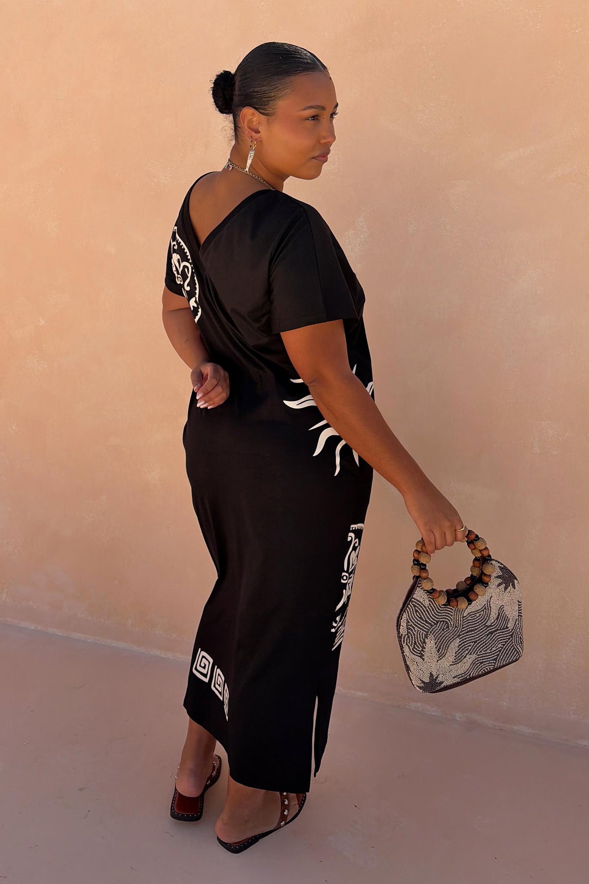 Black cotton Dolce Vita T-Shirt Dress with hand-painted sun motifs and Greek graphics, shown on a size XL model.