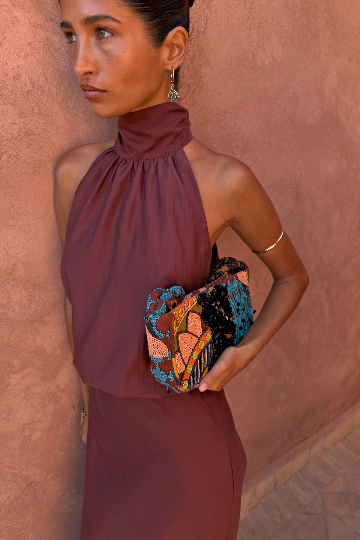Chocolate Billie Top featuring a multi-wear scarf neckline and halter silhouette with a colourful beaded clutch.
