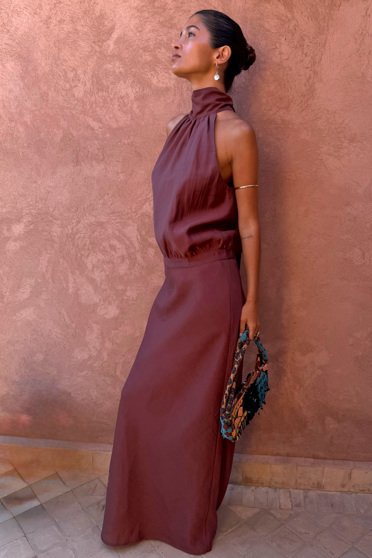 Chocolate Daphne Skirt in a high-waisted straight fit, styled with a matching co-ord top against a clay wall.