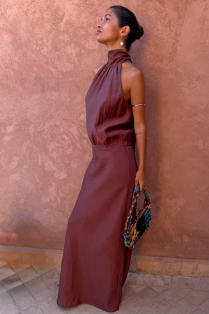 Chocolate Daphne Skirt in a high-waisted straight fit, styled with a matching co-ord top against a clay wall.