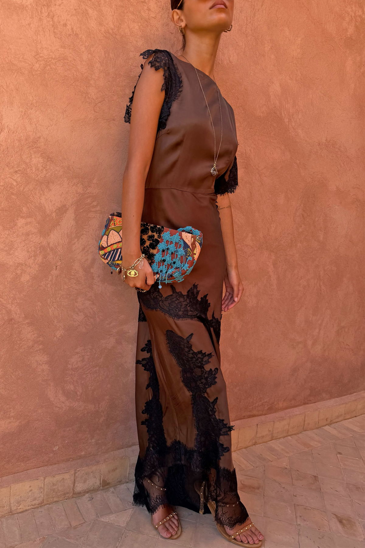 Chocolate Fearne maxi dress with black lace panels and cap sleeves, styled with a beaded clutch bag.