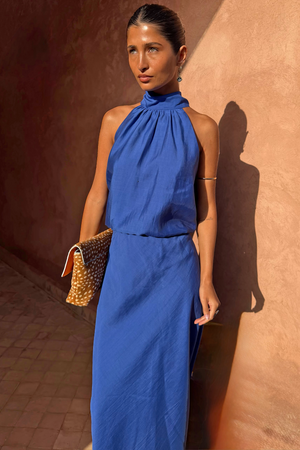 Cobalt Billie Top with a high halterneck and front gathers, styled with a matching skirt in a sunlit setting.