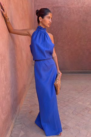 Cobalt Daphne Skirt and matching halter top co-ord in blue, worn by a model leaning against a terracotta wall.
