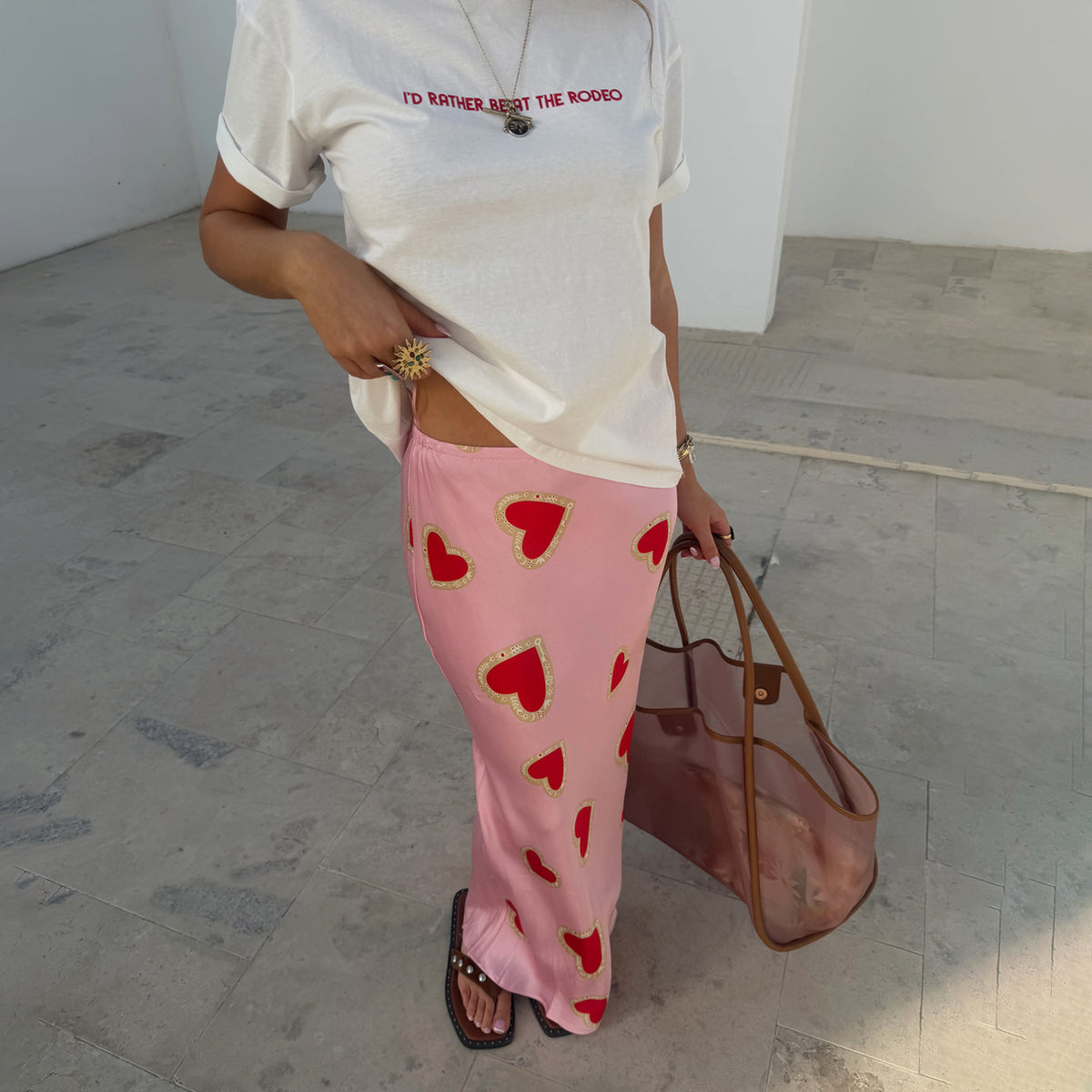 Pink Hearts Dorris Skirt featuring red heart prints and a relaxed midaxi fit, styled with a white graphic tee.