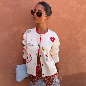 Cardigan bianco Morocco Charms Cheryl con ricami vivaci e bordi rossi indossato da una modella.