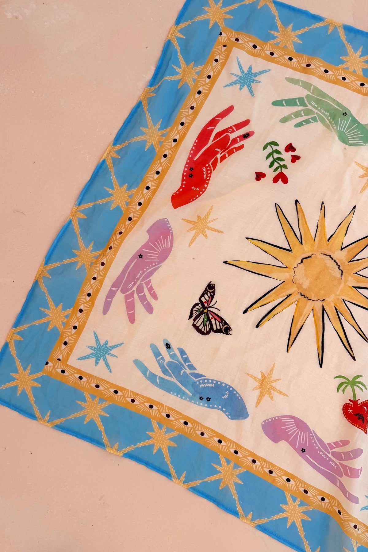 Celestial Bandana featuring a blue border with hand-painted sun, palm, eye, and mystical hand motifs.