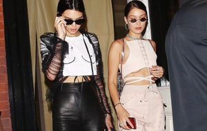 Iconic white Boob T-shirt worn by Kendall Jenner with black leather trousers and a sheer mesh jacket.