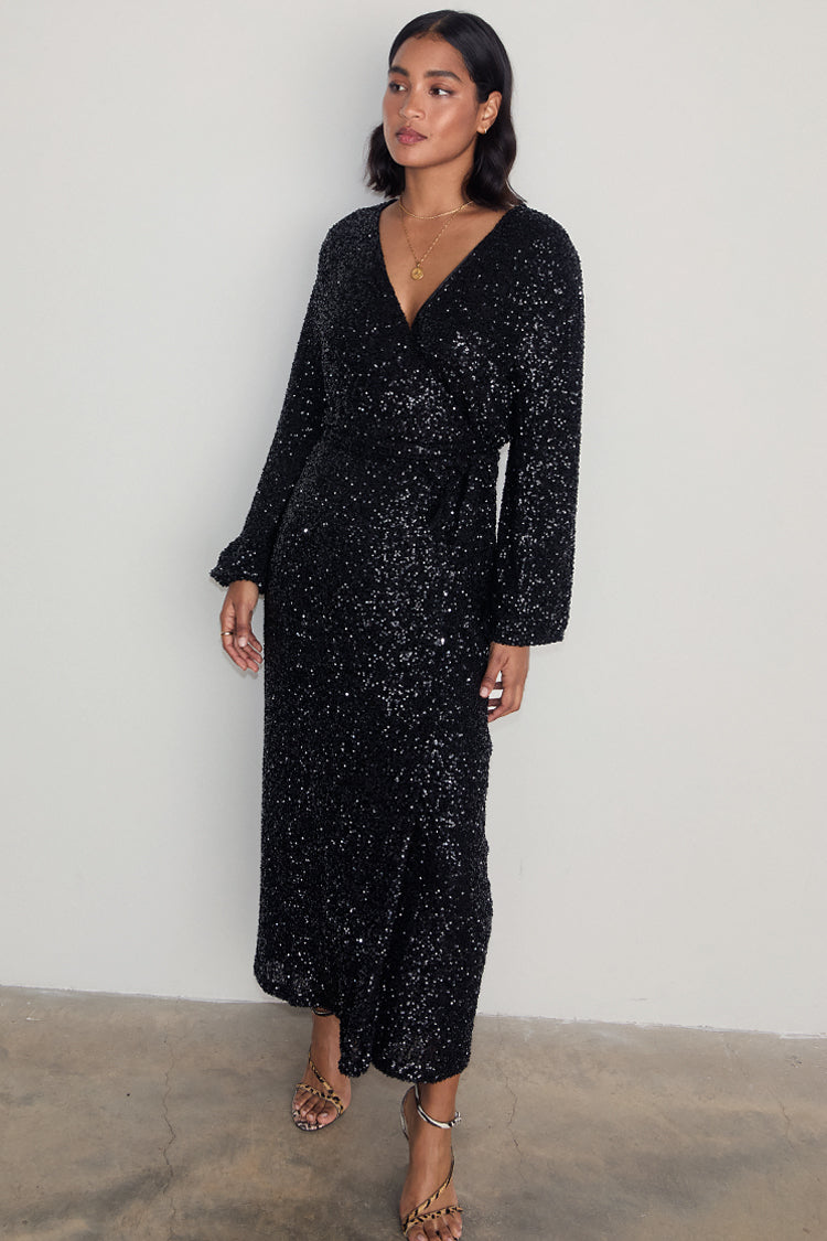 Black Sequin Kira Wrap Dress with long sleeves and midi length, styled with strappy leopard print heels.