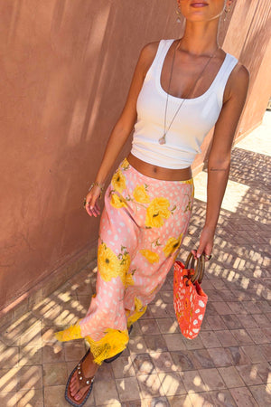 Pink Fawn Poppy Maeva Petite midi skirt with yellow poppy motifs and lace hem, styled for a vacation look.