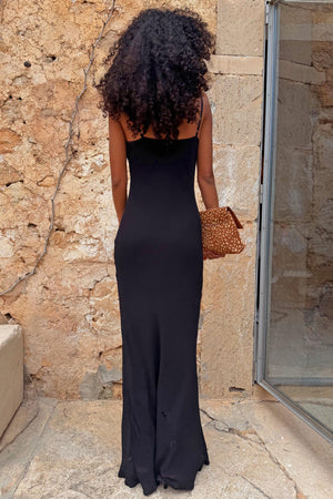 Black Sapna petite maxi dress shown from the back with adjustable straps and a leopard print clutch bag.