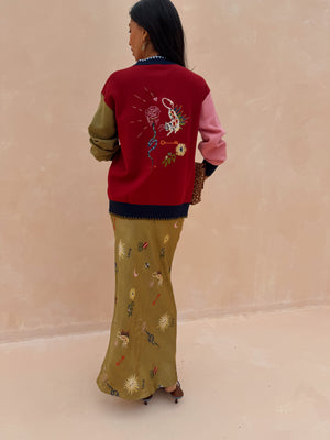 Olive Mystical Dorris Skirt with a celestial print, styled with a red color-block cardigan from behind.