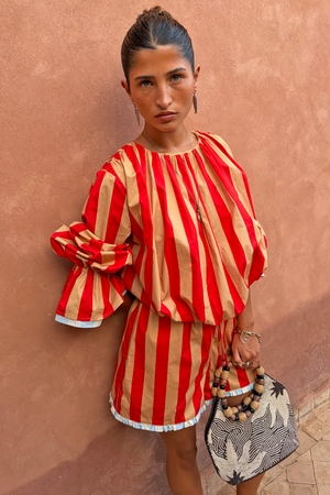 Red and camel Tomato Stripe Blouse with voluminous sleeves and drawstring waist on a model.