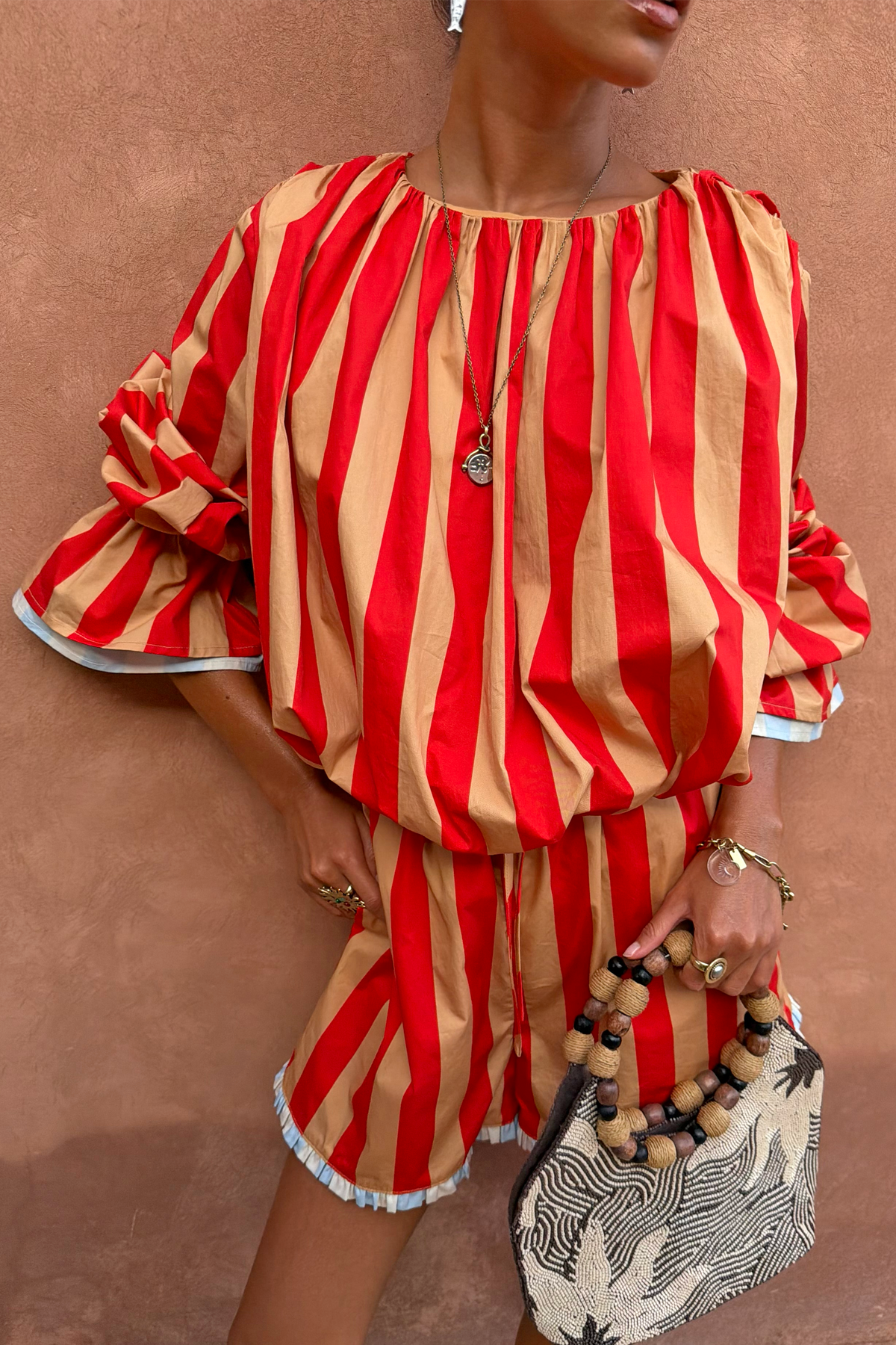 Tomato Stripe Blouse in red and camel stripes with voluminous sleeves and gathered neckline, styled as a vacation co-ord.