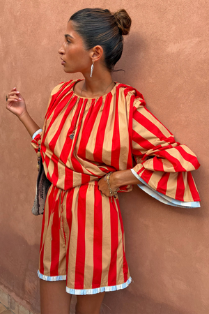 Tomato Stripe Ellie Shorts and blouse co-ord in red and camel stripes with a blue contrast trim.