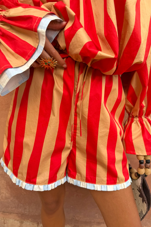 Tomato Stripe Ellie Shorts featuring red and camel stripes, a drawstring waist and blue frill hem.