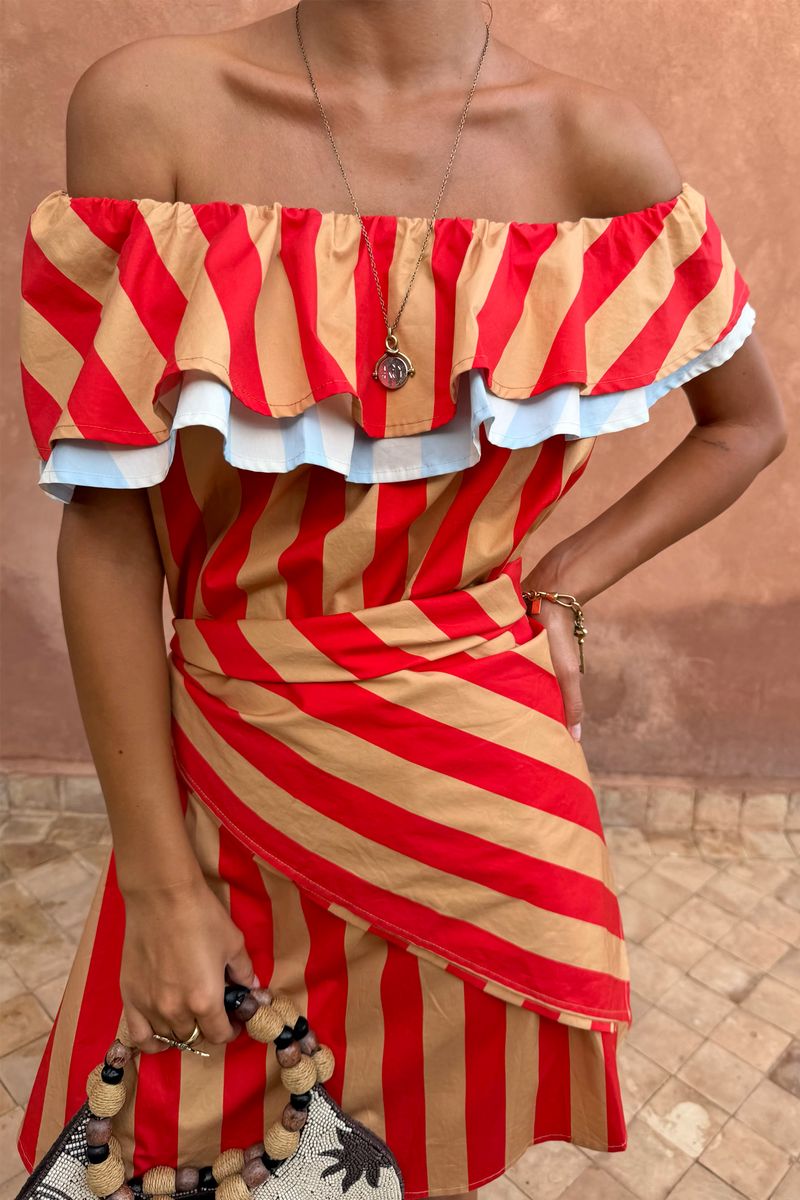 Sciarpa Tomato Stripe rosso pomodoro e cammello, multi-wear in vita su un abito a spalle scoperte.