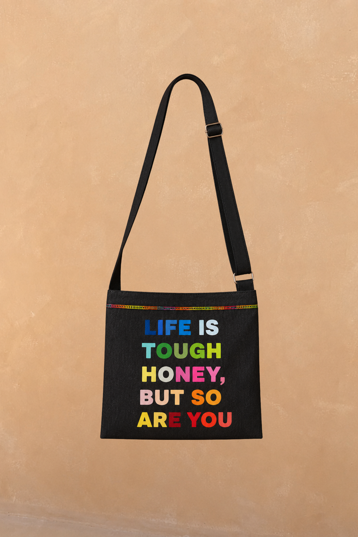Charcoal Life is Tough Honey Drainage Bag with multicoloured lettering, rainbow stitching and an adjustable crossbody strap.