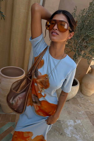 Ice Blue Floral Rib Dress with a bold orange floral print and ribbed texture, styled with oversized sunglasses.