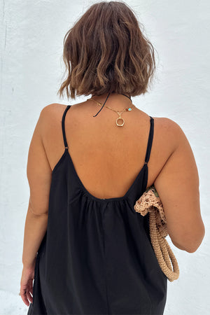 Black Rio Maxi Dress featuring a gathered scoop back and adjustable spaghetti straps, styled with a gold necklace.