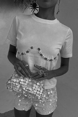 Shells Hot Pants in cream with pearlescent shell beads, styled with a matching shell-embellished t-shirt and bag.