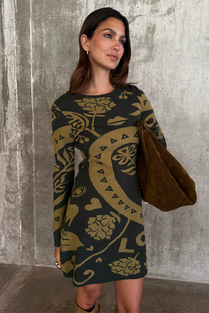 Olive Amara Knit Mini Dress featuring iconic motifs on a soft khaki knit base, paired with a suede bag.