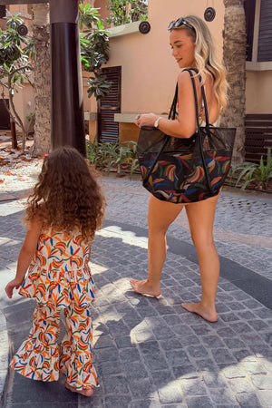 Black Mesh Tote Bag with leather shoulder straps and a banana print pouch for a family vacation look.
