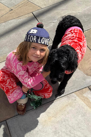 Red and Pink Bandana Dog Jumper on a black dog, paired with a matching kids' bandana print knitted set.