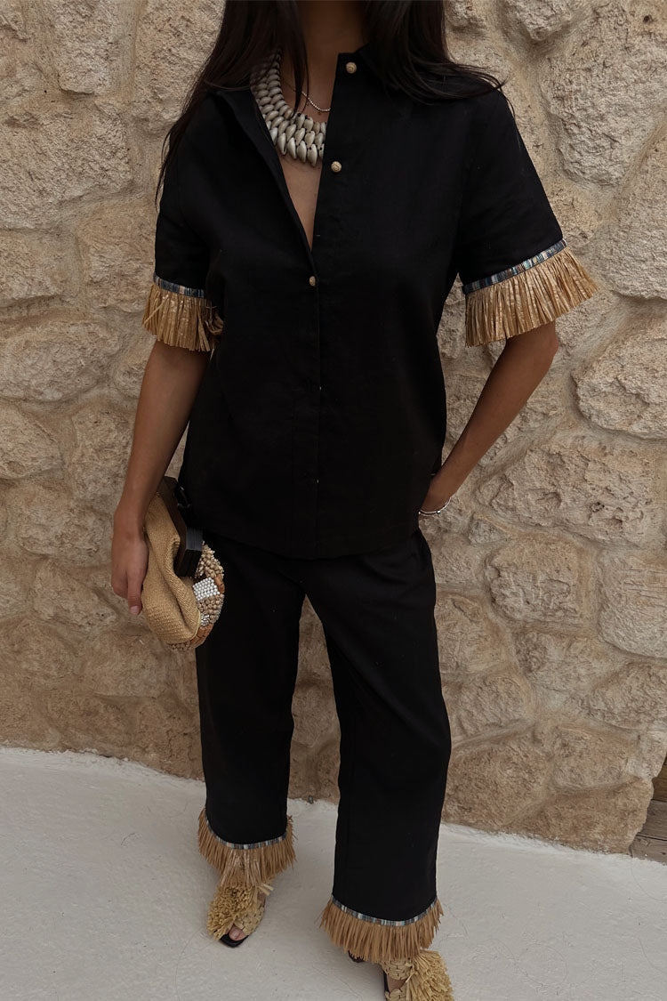 Black Raffia Marra Trousers with fringe hems, styled as a co-ord with a matching shirt and raffia clutch.