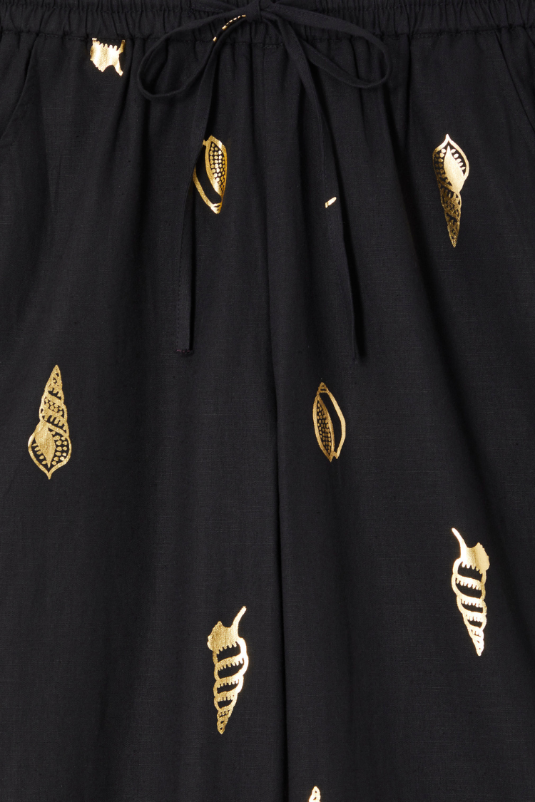 Black Shell Elissa Trousers detail showing the elasticated drawstring waist and metallic gold shell print.