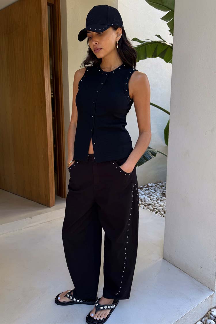 Jeans barrel neri con borchie laterali e top nero; la modella è alta 170 cm e indossa la taglia 40.