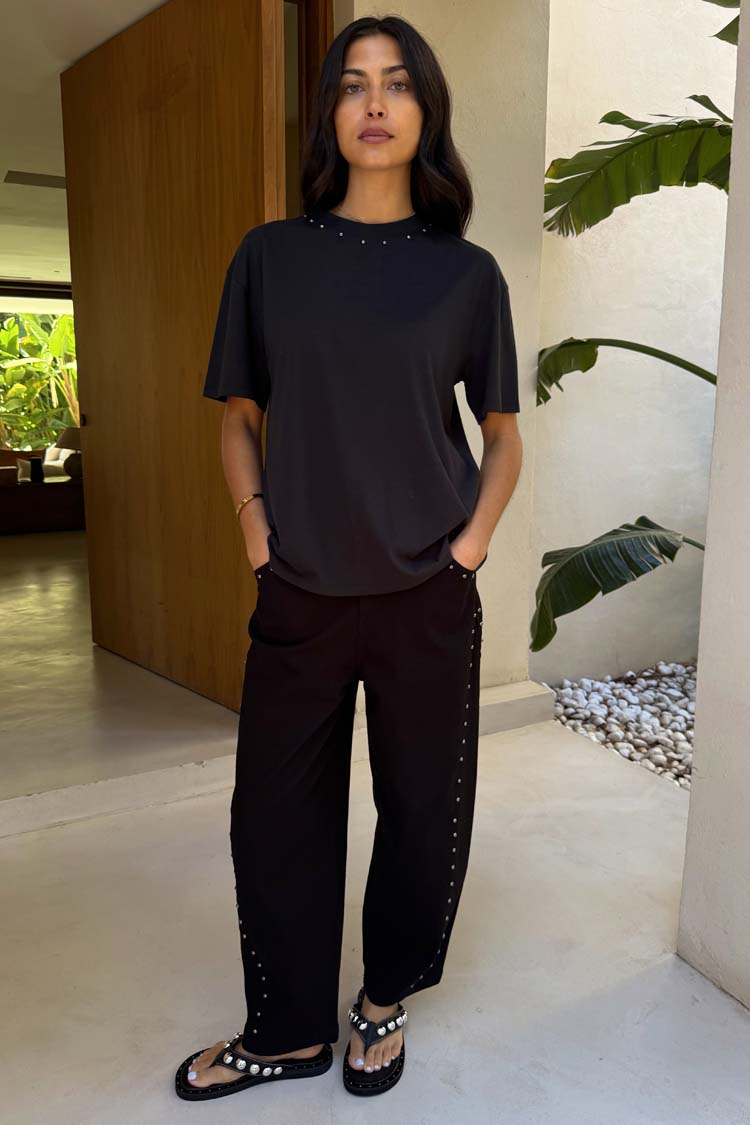 Jeans barrel neri con borchie laterali; la modella è alta 170 cm e indossa la taglia UK 8 / US 4.