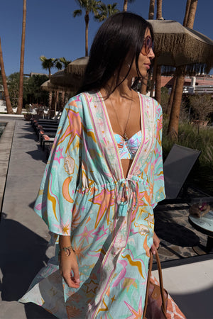 Blue Dreamer Maxi Kimono with colourful sun and heart motifs, featuring a flowy silhouette in a sunny poolside setting.