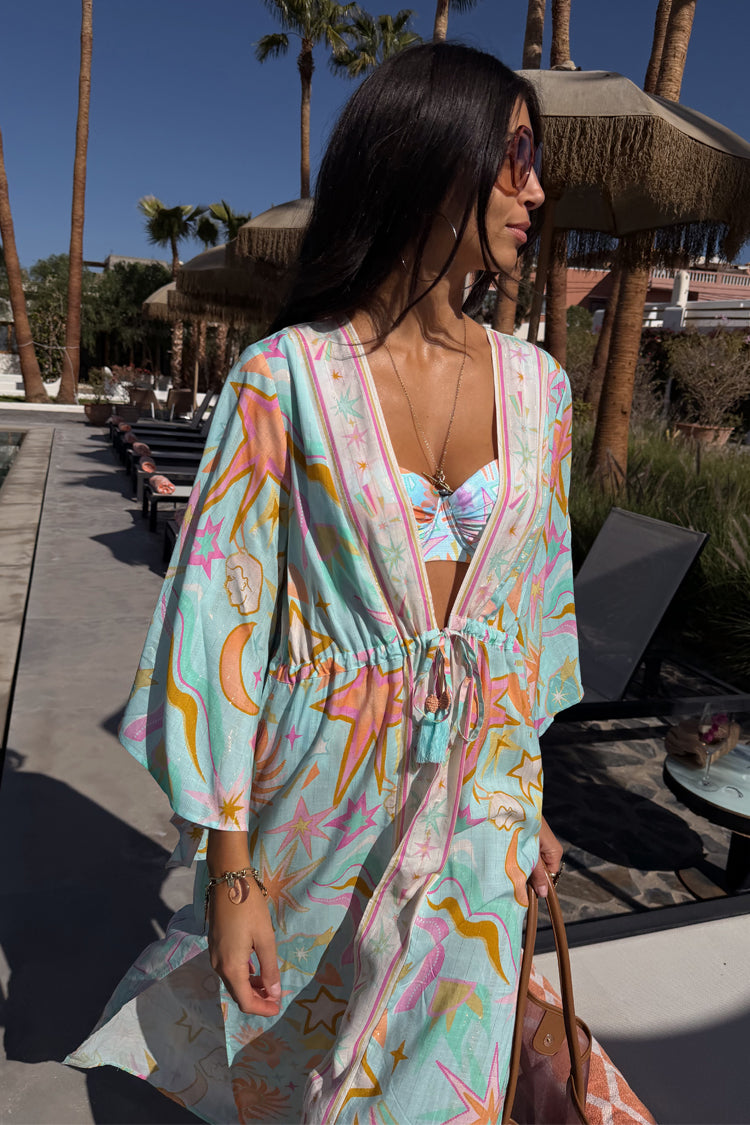 Blue Dreamer Maxi Kimono with colourful sun and heart motifs, featuring a flowy silhouette in a sunny poolside setting.