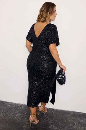 Black Sequin Bow Dress with a V-back and velvet tie detail, showcasing inclusive sizing in a midi length.