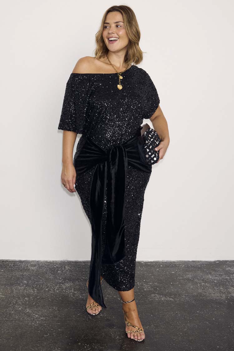 Black Sequin Bow Midi Dress with a velvet tie waist and off-the-shoulder neckline for party season styling.
