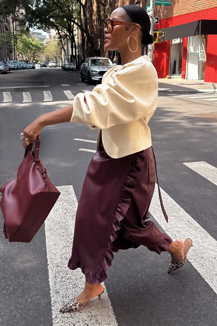 Burgundy Vegan Leather Ruffle Jaspre Skirt with side ruffles and leopard print heels on a city crossing.