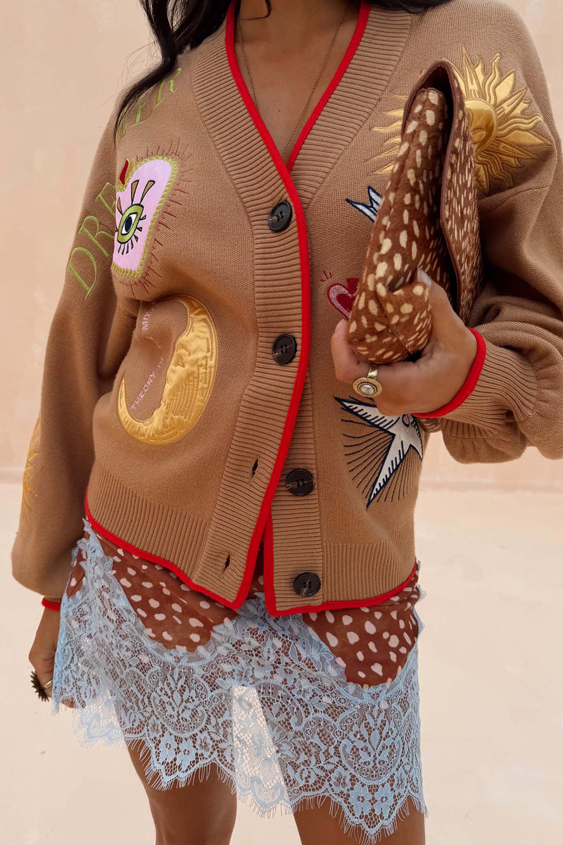 Camel Mystical Cardigan with sun, moon and star embroidery and red trim, styled with a leopard print clutch.