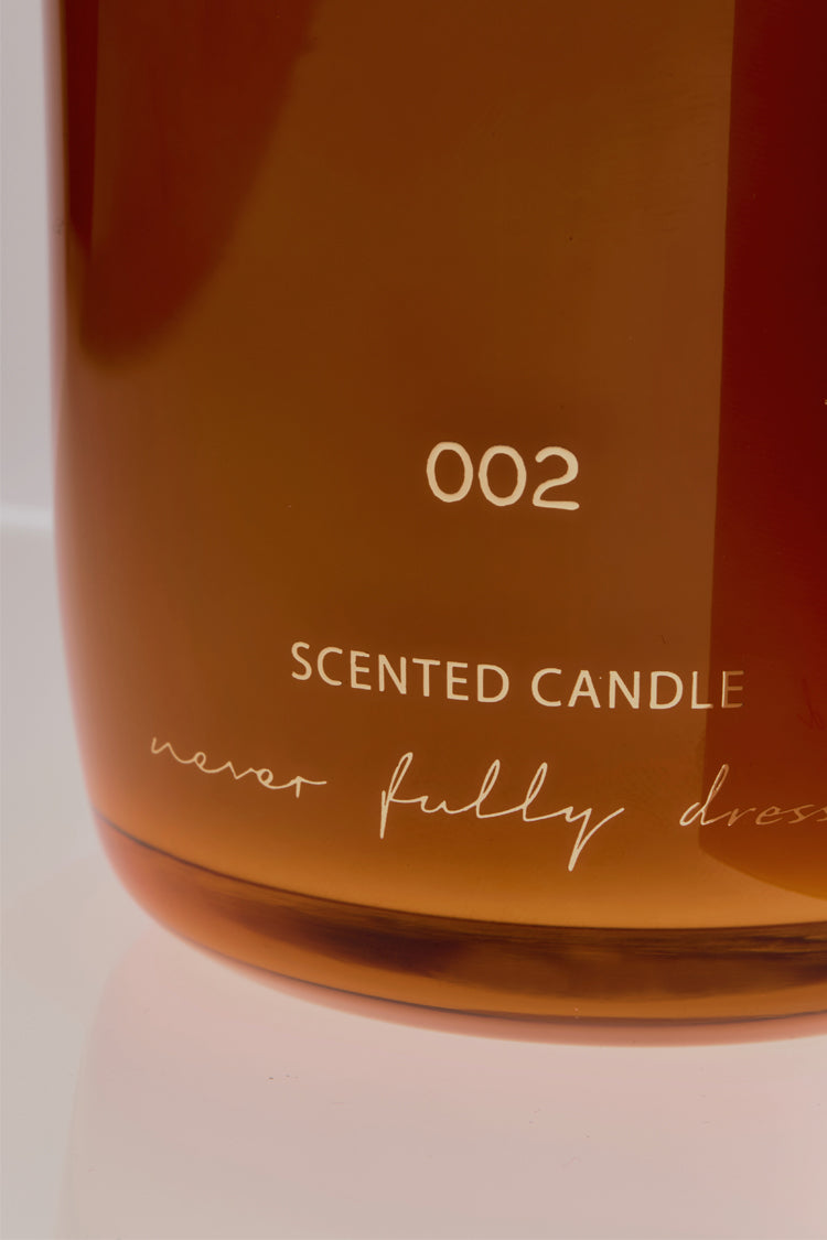 NFD Eau De Parfum Candle 002 in an amber glass jar with gold lettering and the signature cursive logo.