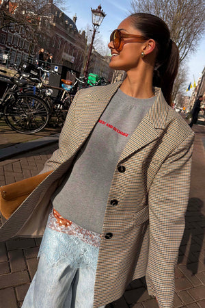Blazer a quadri gialli e neri su una felpa grigia con scritta per un look London street style.