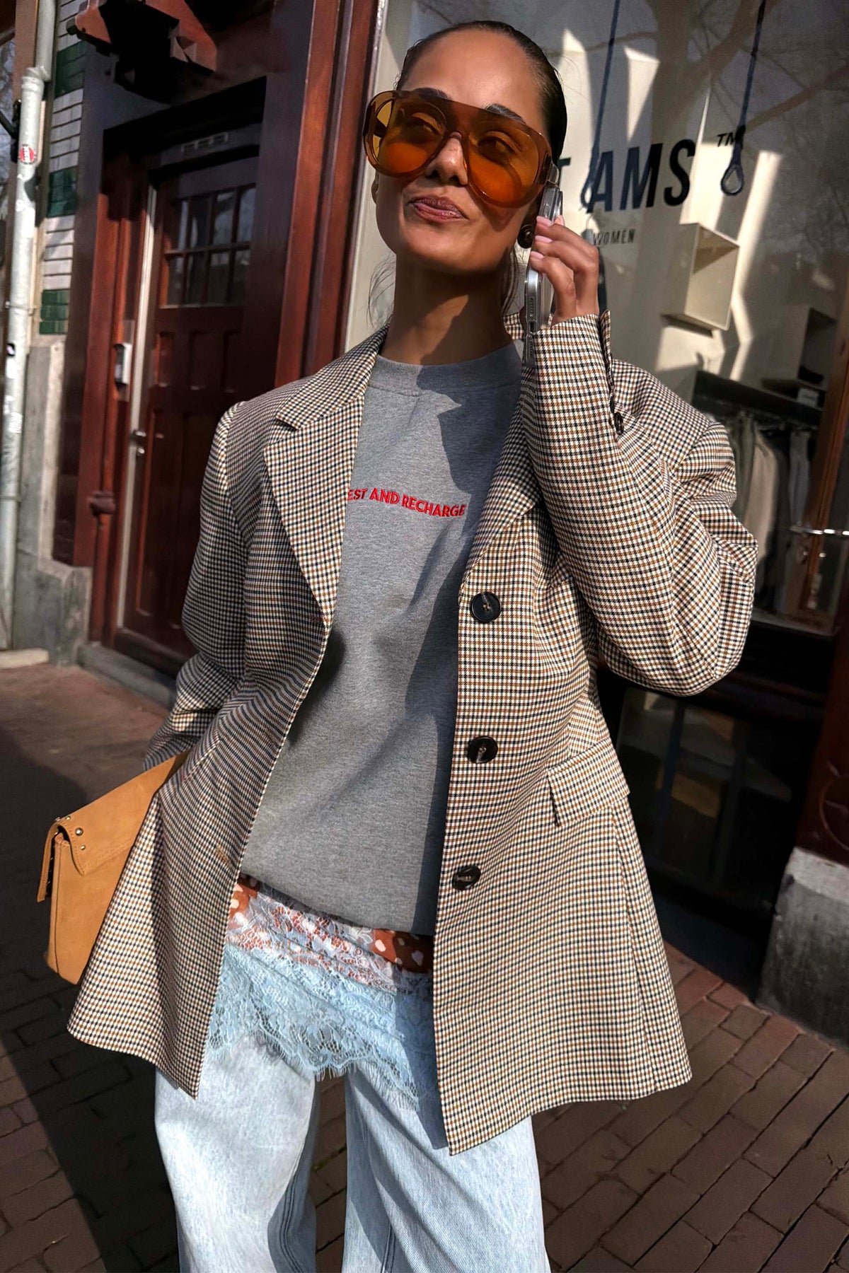 Blazer sartoriale a quadri abbinato a una felpa grigia e occhiali da sole oversize per un London look.